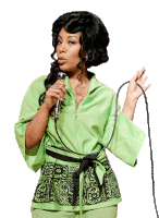 a woman in a green jacket holds a microphone in her hand