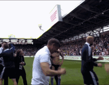 a man in a white shirt stands on a soccer field in front of a sign that says the best lap of appreciation