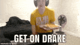 a man wearing headphones is holding a tray of food with the words get on drake below him