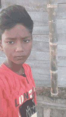 a young boy wearing a red shirt that says lone