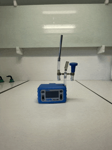 a blue device with the word plus on it sits on a white table