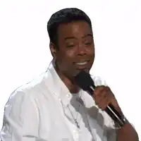 a man in a white shirt is holding a black microphone and smiling