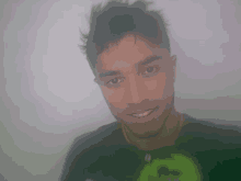 a man wearing a black shirt with a green g on it smiles for the camera