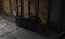 a black and orange motorcycle is parked in front of a wooden wall