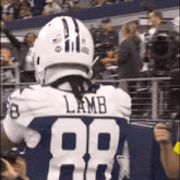 a football player named lamb wearing a white helmet and number 88 jersey