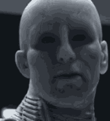 a black and white photo of a bald man 's face with a very serious look on his face .