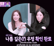 two girls are making a heart shape with their hands and the caption says verificando cuan
