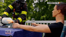 a woman sits at a table with a fireman behind her and the words inside edition on the table cloth