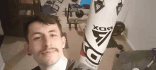 a man with a mustache is holding a boxing bag that says rdx