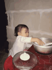 a little girl playing with a bowl of food