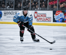 a hockey player on the ice with an advertisement for wagner appliance in the background