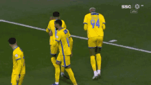 soccer players wearing yellow jerseys with the number 94 on the back