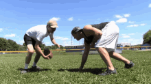 two men are playing a game of football on a field with a sign in the background that says ' a ' on it