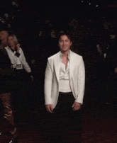 a man in a white suit is making a middle finger gesture