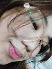 a close up of a woman wearing glasses and a pink lip