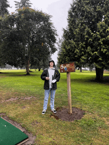 a man stands next to a sign that says 5