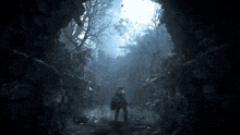 a person is standing in a dark cave with a sword in a video game .