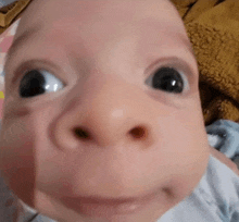 a close up of a baby 's face making a funny face and looking at the camera .