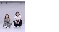 two women are squatting on the floor in front of a wall .