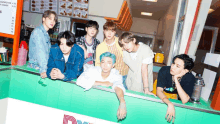 a group of young men are posing for a picture in a diner with a menu behind them