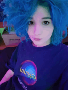 a girl with blue hair is wearing a t-shirt that says ' inimso ' on the front