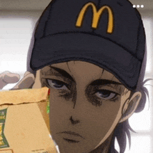 a man wearing a mcdonald 's hat is holding a bag of food in front of his face .