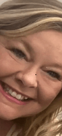 a close up of a woman 's face with a nose ring smiling .