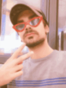 a blurry picture of a man wearing red sunglasses and a baseball cap