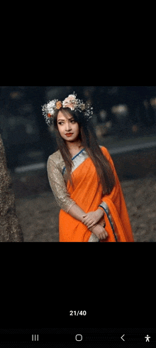 a woman in an orange saree and a flower crown