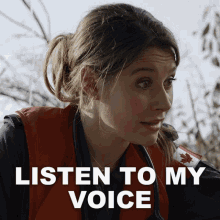 a woman wearing a red vest with a canadian flag on it and the words listen to my voice above her