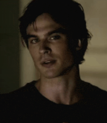 a man in a black shirt is looking at the camera .