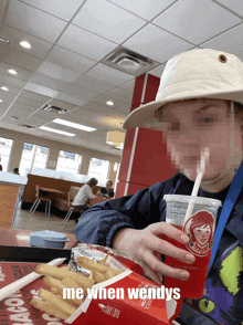 a person drinking a wendy 's beverage with a straw