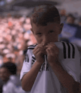 a young boy wearing a white shirt with the letter r on it