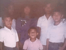 a group of children are posing for a picture together and one of them is laughing .