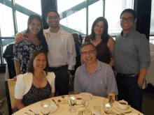 a group of people sitting around a table with glasses of wine