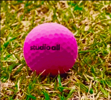 a pink golf ball with studio all written on it