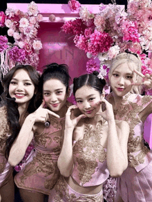 four girls pose for a picture in front of a pink sign that says pink