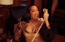 a woman in a leopard print top is talking on a telephone .