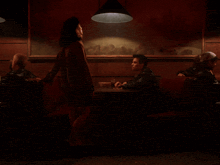 a man sits at a table with a woman standing in front of him