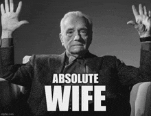 a man in a suit is sitting in a chair with his hands in the air and the words absolute wife above him