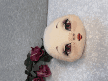 a stuffed doll with a red lip and freckles