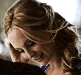 a close up of a woman 's face with a hand on her head