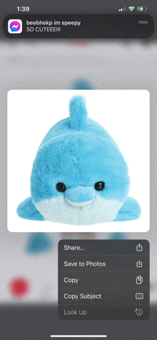 a blue stuffed dolphin is displayed on a cell phone screen