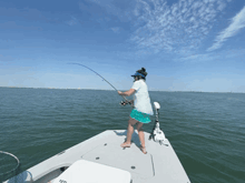 a woman is fishing on a boat that says yeti