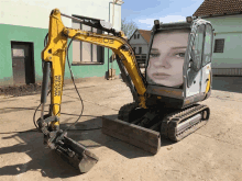 a yellow excavator has a picture of a woman on the side