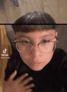 a young boy wearing glasses and a black shirt .