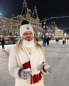 a man wearing a white hat and scarf is standing on a ice rink