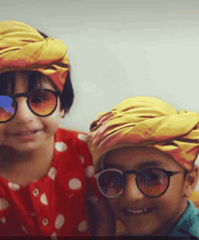 a boy and a girl wearing sunglasses and turbans