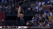 a baseball player holds his glove in the air in front of a crowd with the score 7 to 0