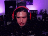 a man wearing red headphones is making a funny face while playing a video game .